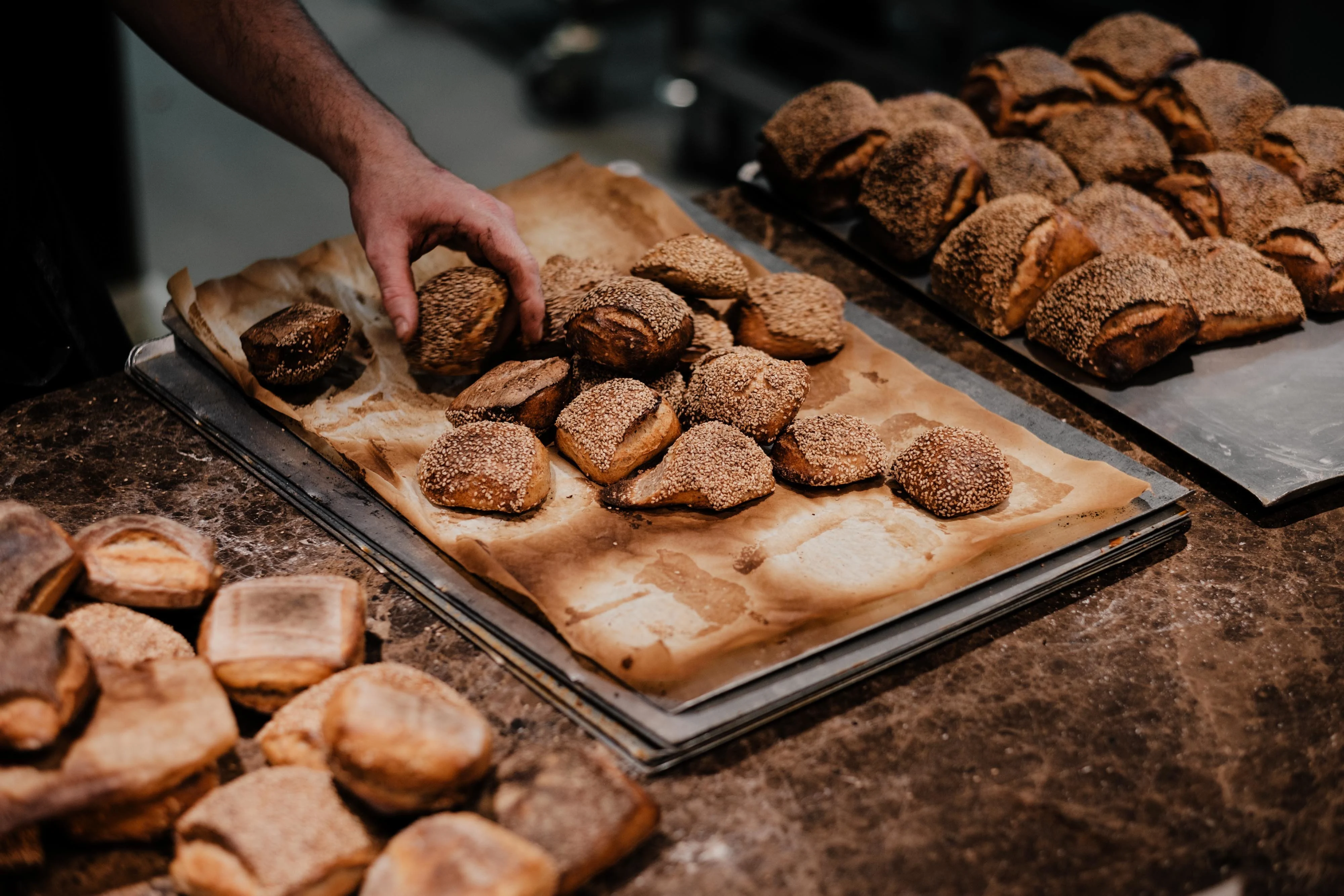 Fresh bread, flour, and baking ingredients arranged on a worktable